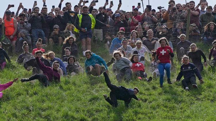 Woman wins chaotic cheese rolling race despite being knocked unconscious