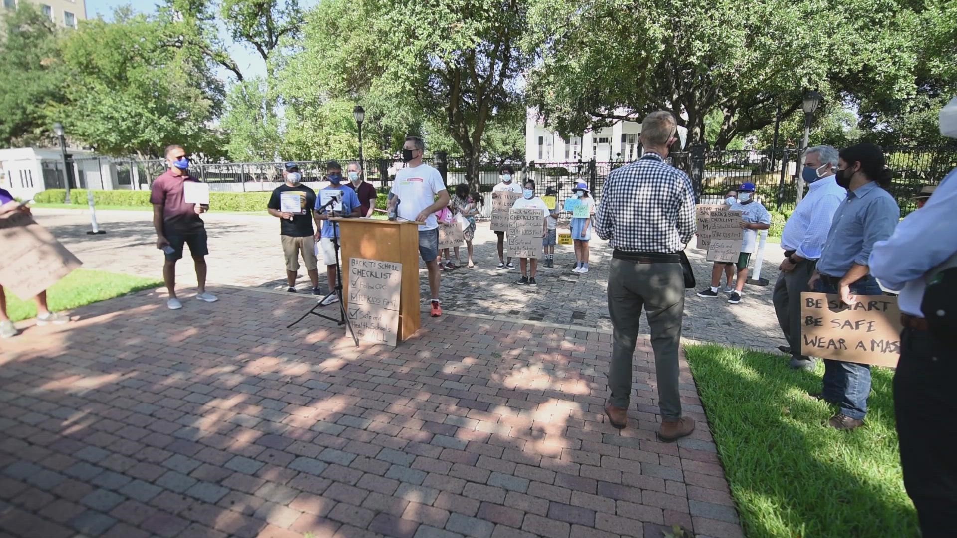 A group of parents and students gathered at the Texas governor's mansion on Monday to protest his executive order banning face mask mandates.