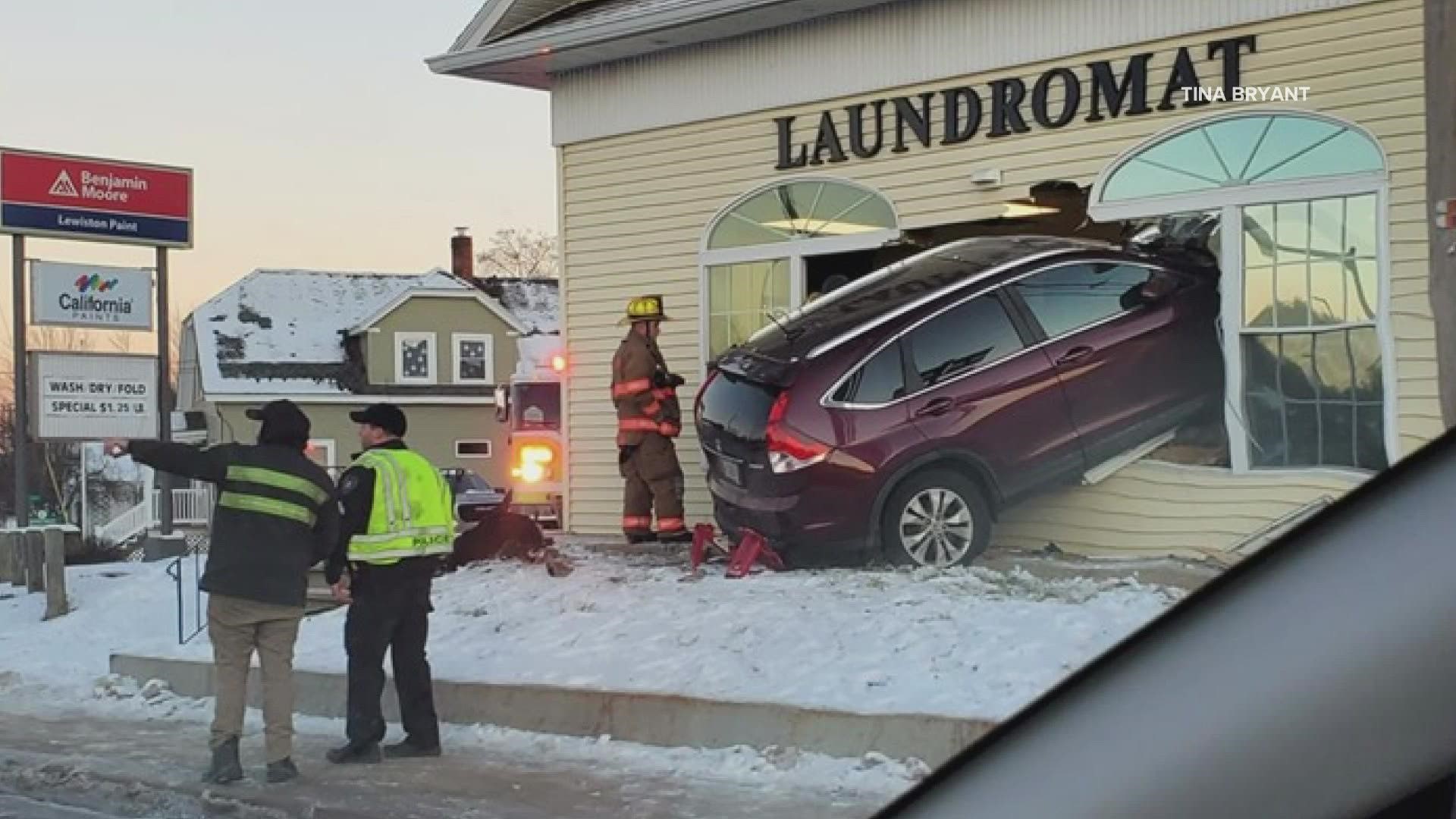 A two-vehicle crash Monday morning sent a car through the front of a laundromat in Lewiston.