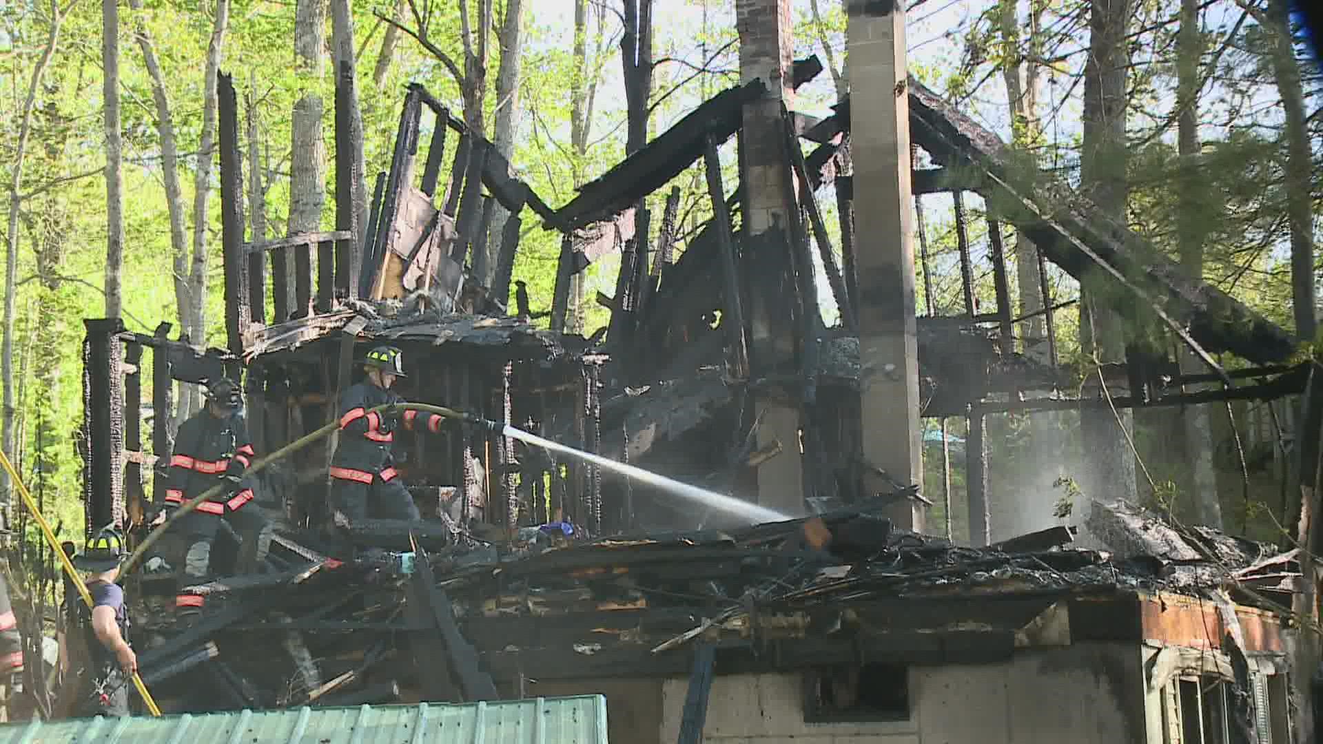 Neighbors and a crew from Central Maine Power helped save the life of a woman whose house erupted in flames Wednesday afternoon.