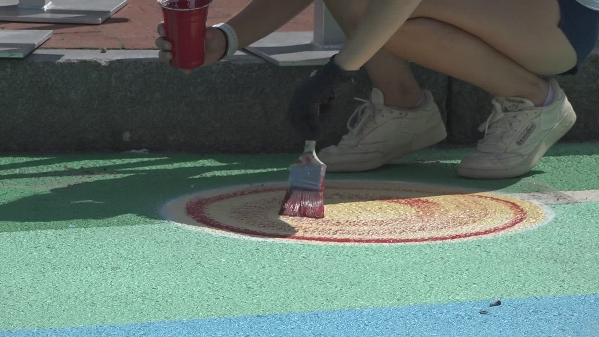 The art covering the ground at Vallee Square shows a musical staff and colorful notes of the African-American spiritual song "Wade in the Water."