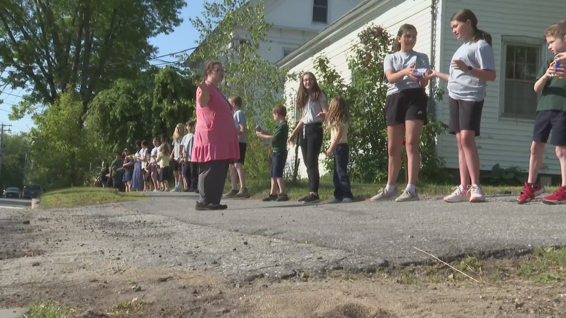 Dozens of St. John's Catholic School students line up every year across the neighborhood to pass along food to the Mid Coast Hunger Prevention Program.