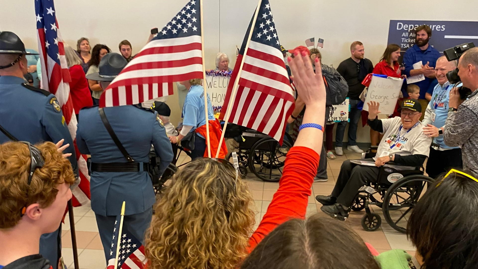 A crowd of more than 150 people packed into the Portland Jetport terminal to cheer the veterans after they got off the plane.