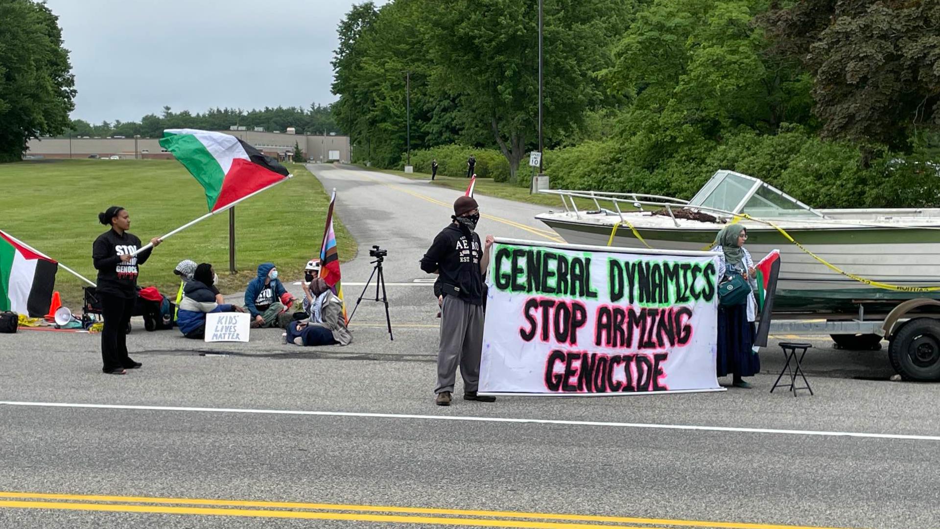 The group of about 20 was seen with banners and signs in support of Palestine. They had a boat hooked to a trailer blocking the front entrance.