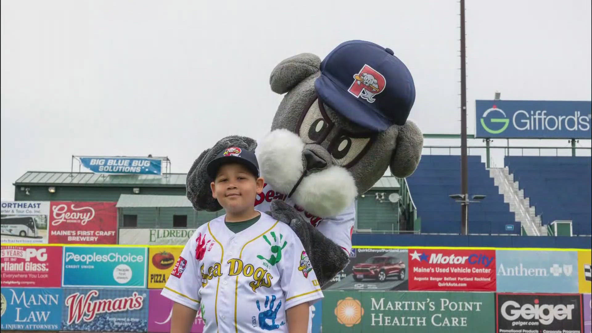 This year's Slugger Kid is 9-year-old Aiden Palmer, who suffers from a high-risk cancer. Palmer squared up with Sea Dogs mascot Slugger in a fundraising match-off.
