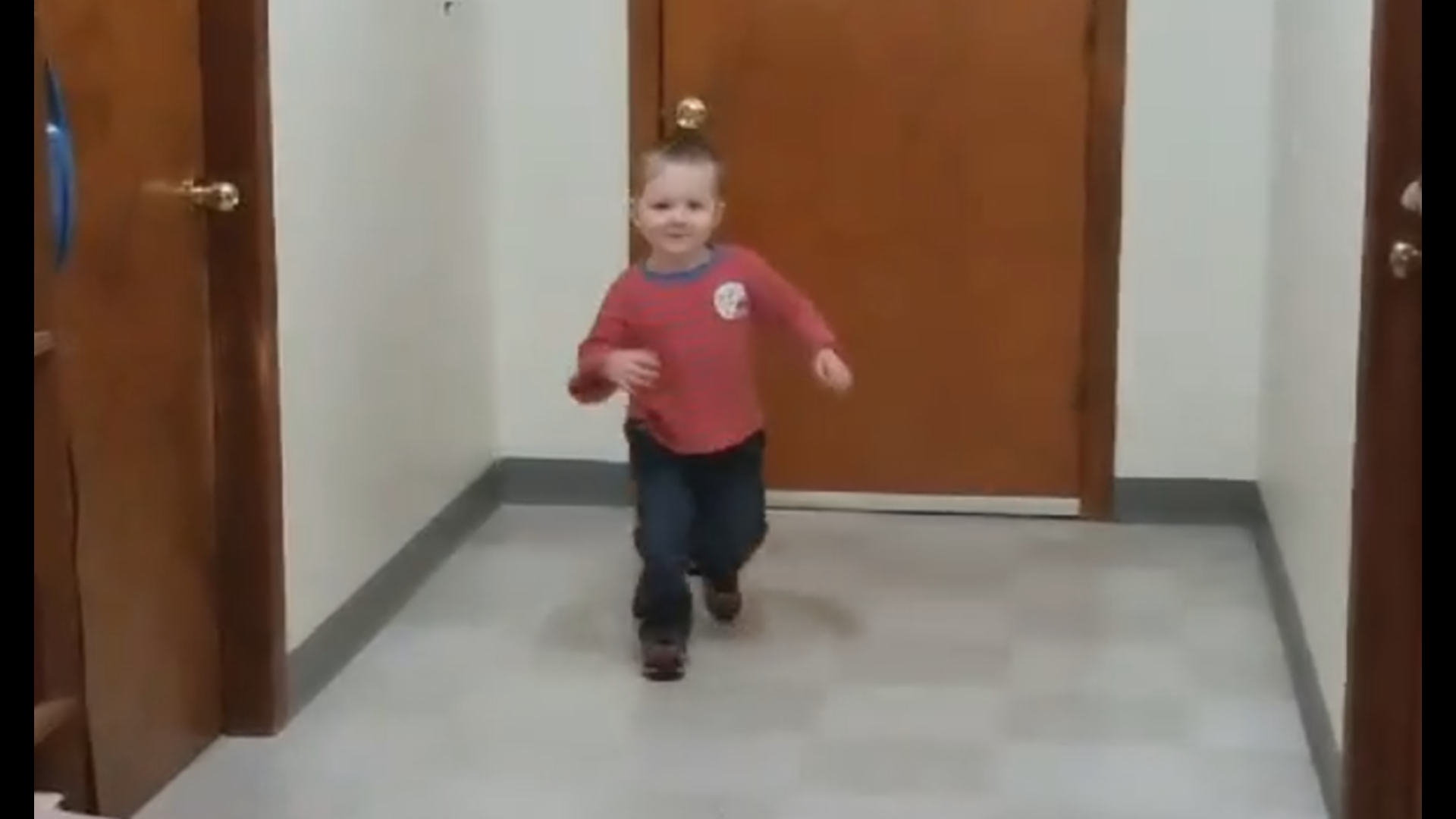 Enoch McGovern running down a hallway, laughing.