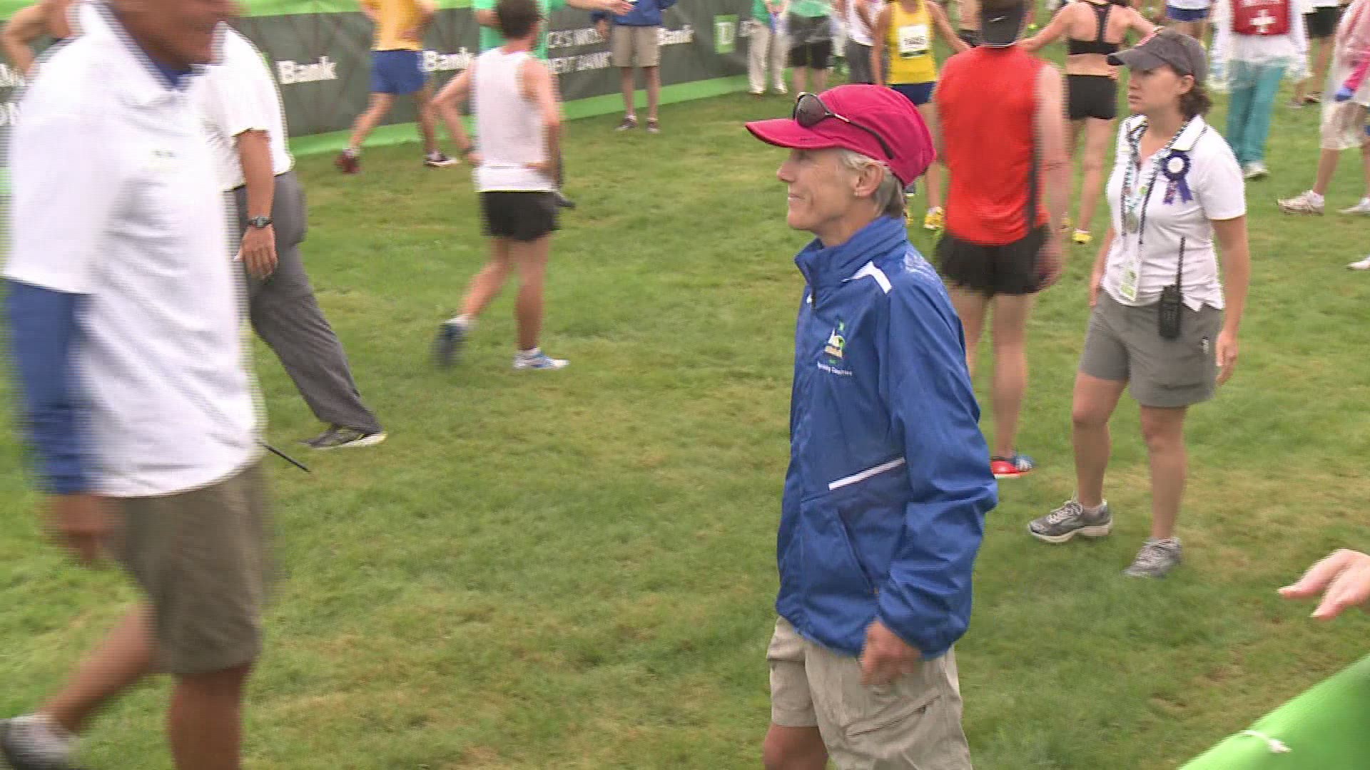 Beach to Beacon founder Joan Benoit Samuelson congratulates runners as they cross the finish line in the 2014 race